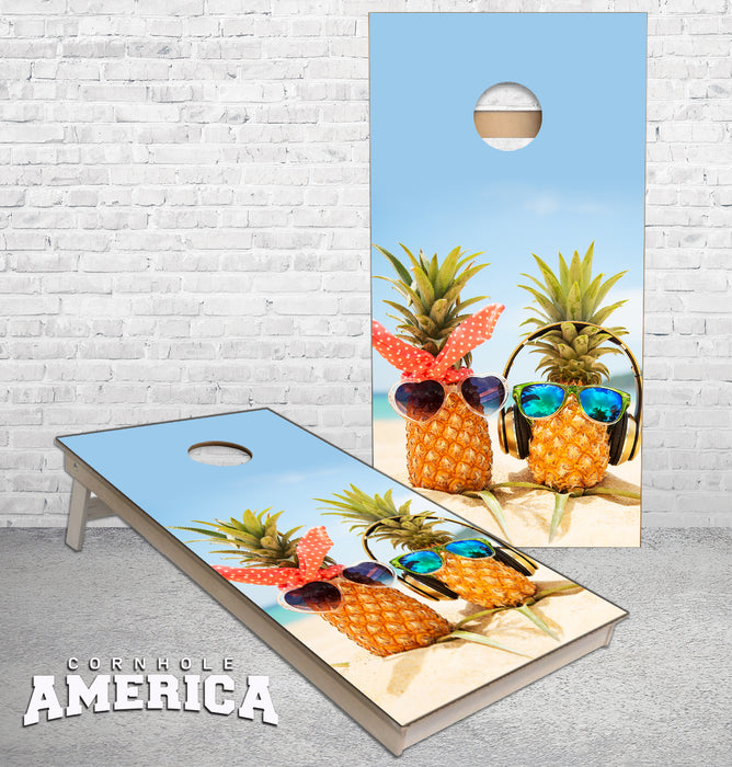 Pineapple Beach in sunglasses and headphones cornhole boards